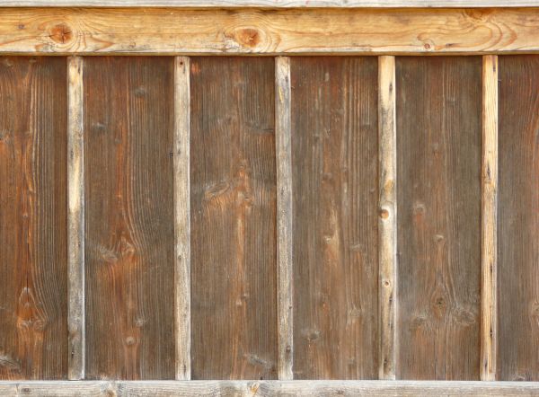 Old wood paneling with thin planks set vertically at repeating intervals.